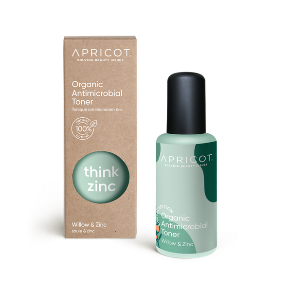 The organic antimicrobial toner with willow and zinc has a rectangular natural cardboard packaging with a round viewing window, reading the product name think zinc, on light, matt mint turquoise. Next to it is the glass bottle with a black screw cap. 